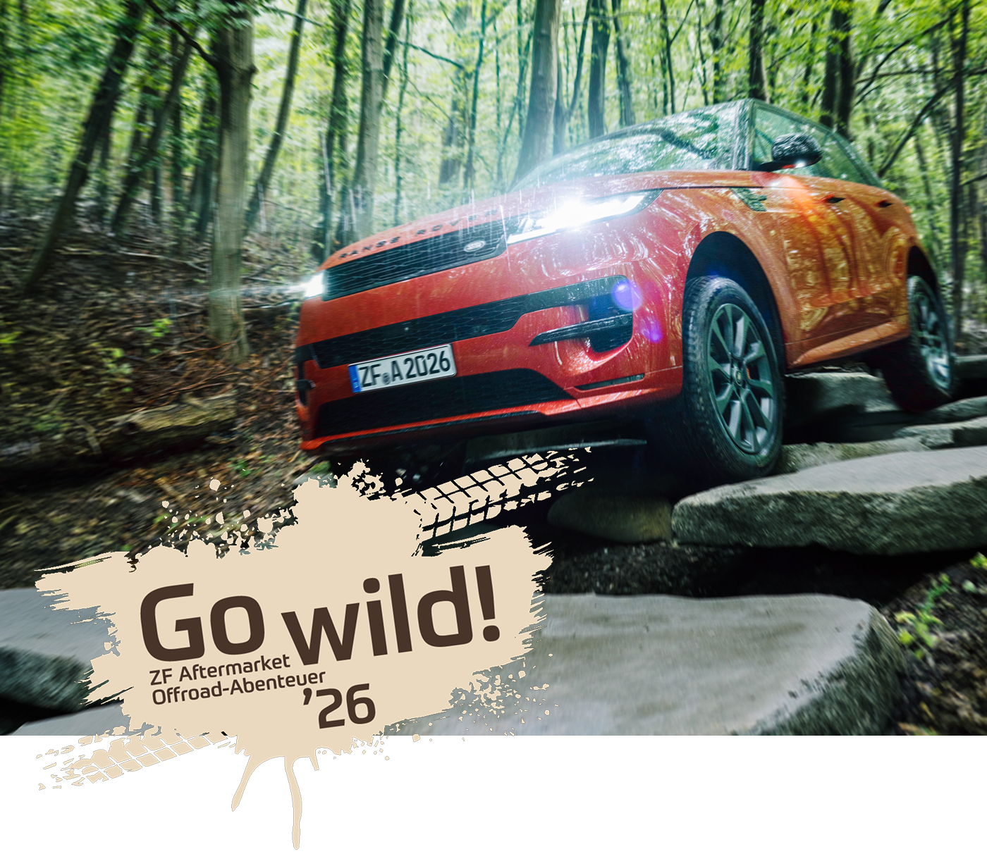 Ein roter Geländewagen rollt eine steinige Straße durch den Wald auf uns zu. Links ein Fleck mit Reifenspuren und dem Schriftzug: 'Go wild! 2026' ZF Aftermarket Offroad-Abenteuer.